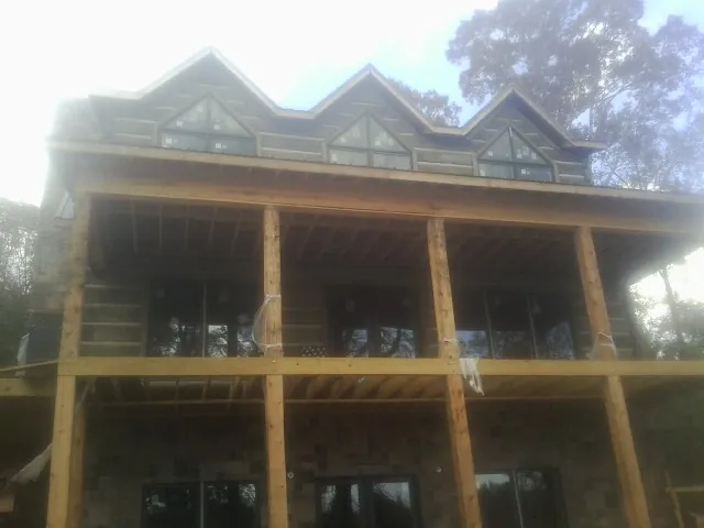 Dormers and porch framing on a large log home under construction — Roof Coating work by our crew in Philadelphia